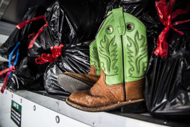Green Cowgirl boots placed in the trash