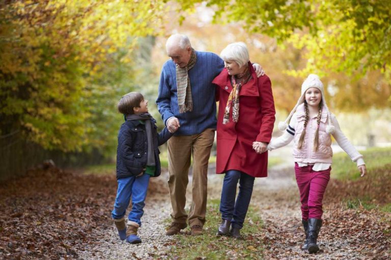 Grandparents go for a fall hike with their grandkids.