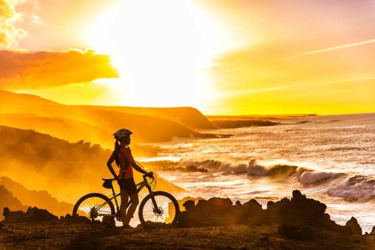 Lady posing on bicycle in front of a pretty sunset