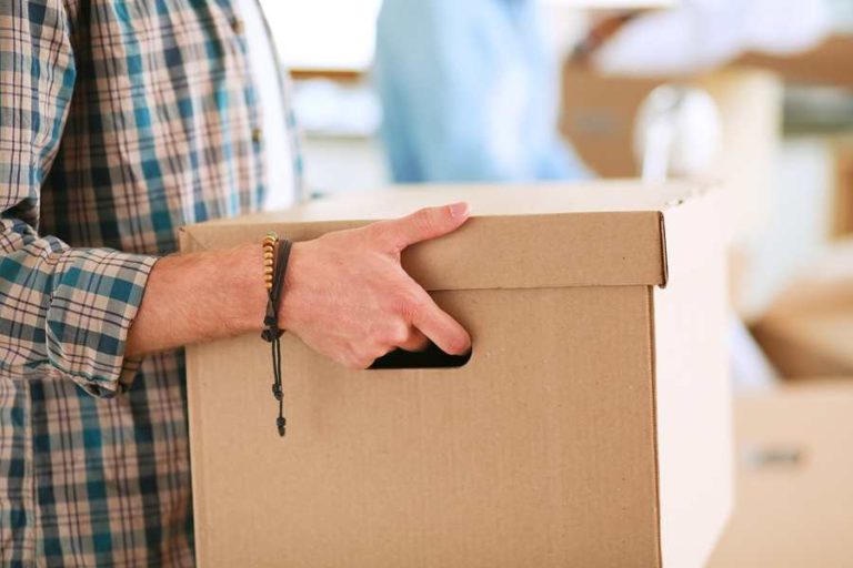 Zoomed in photo of a man moving a box