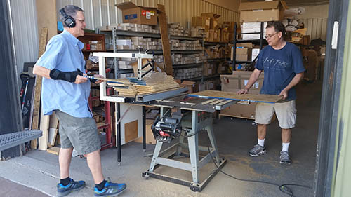 From left, Dan and Mike Taylor make custom shelves to store tools they sell from their commercial storage unit.