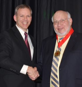 Red Cross hero Ed Brooks shaking hands.