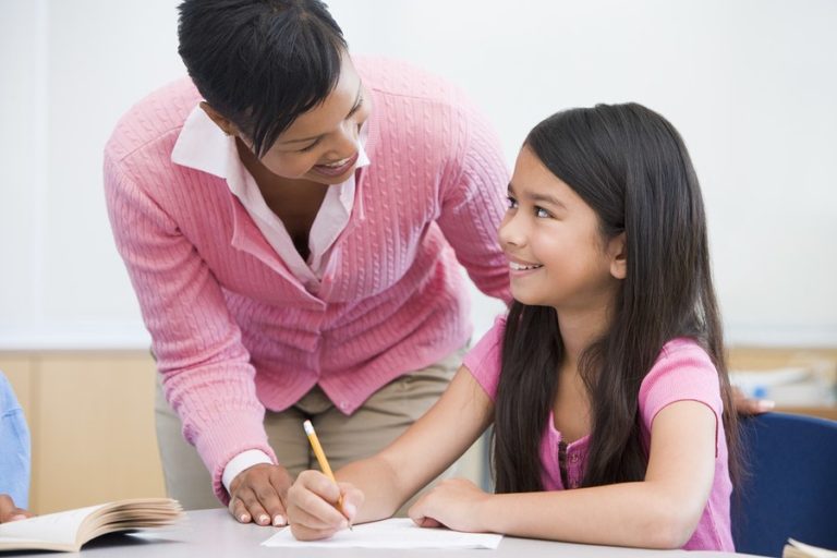 Lady helping younger girl with schoolwork