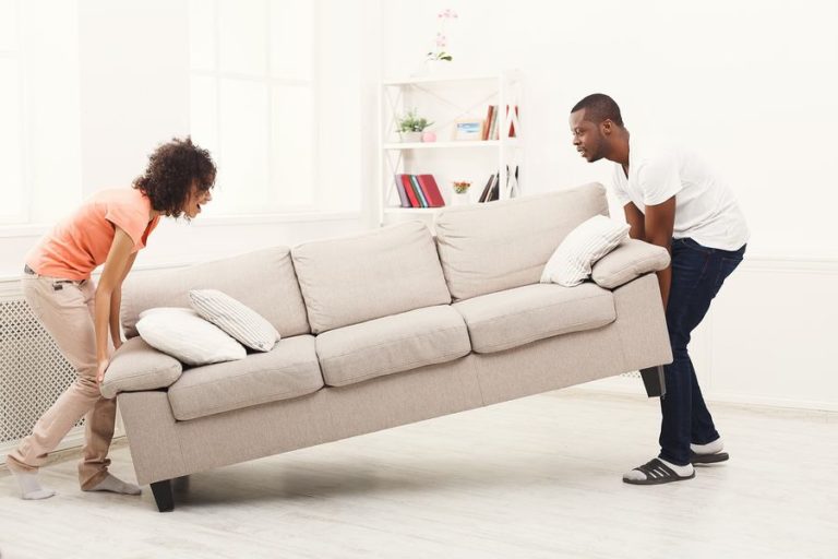 Couple working together to move a couch