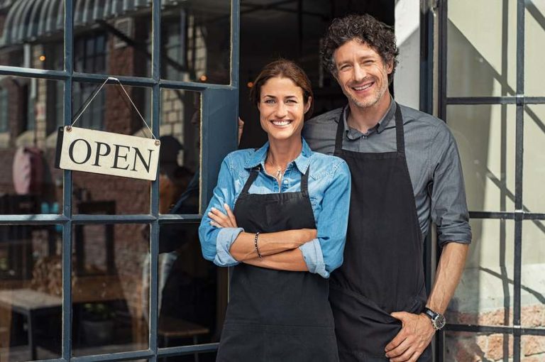 Couple posing in front of their store