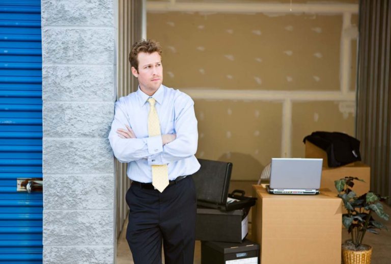 Man posing in front of freshly moved in storage unit