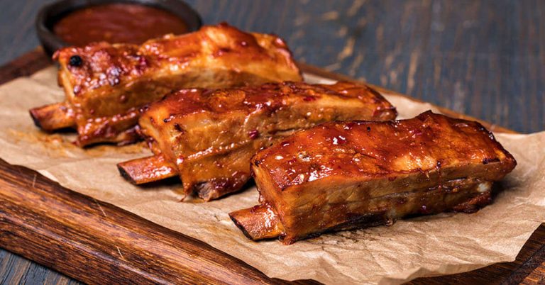 A platter of Columbia Missouri BBQ ribs lightly covered in BBQ sauce