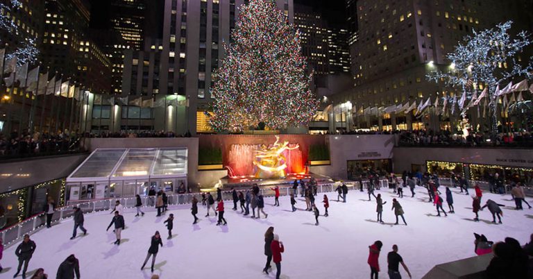 A photo of ice skating and hoilday trees.