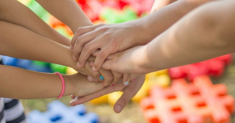 Children's hands joined together in a circle.