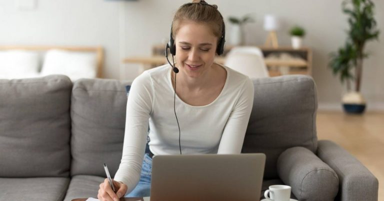 A young woman talking to a customer over a headset.