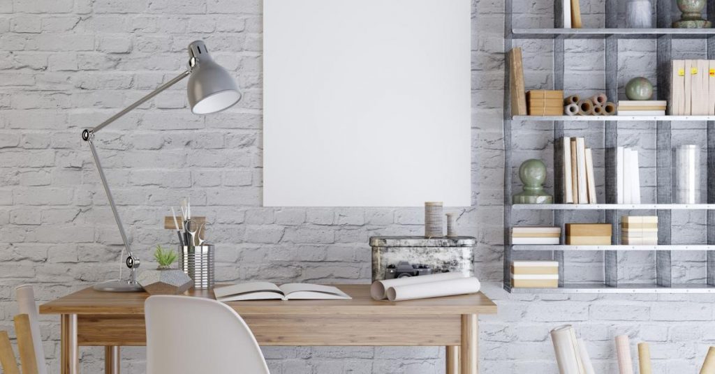 an image of a wooden desk at home with organized shelves to the right of it holding a variety of office supplies