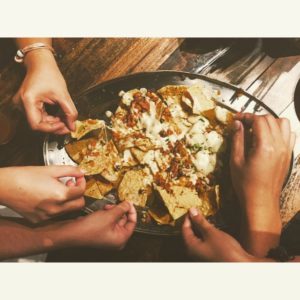 Friends eat loaded nachos during the big game
