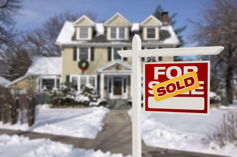 Snow Covered house With A Sold Sign