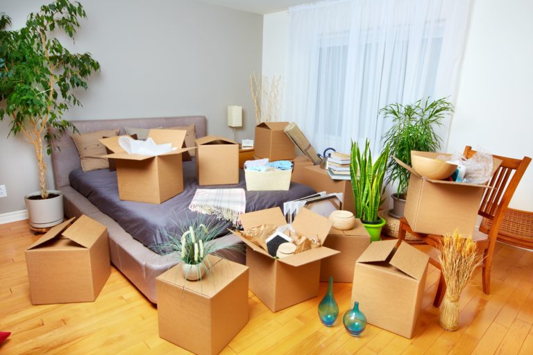 Bedroom with moving boxes packed and spread around the room