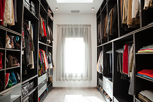 A spare room converted into an organized closet with built-in shelving.
