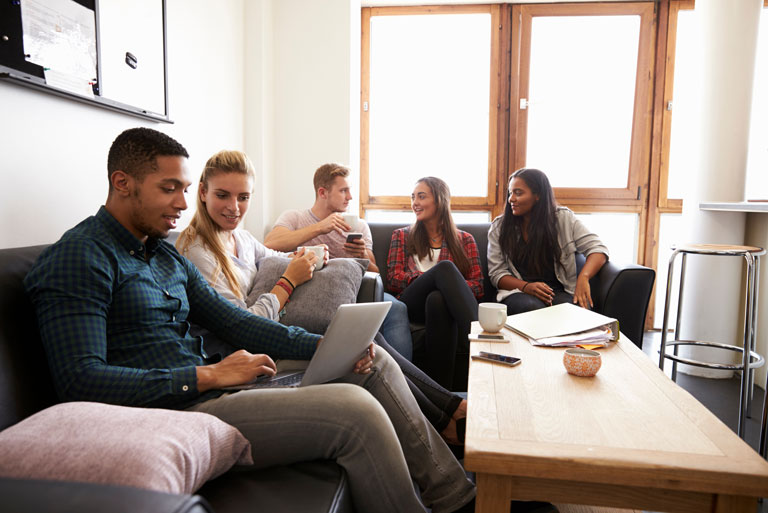 Five college students hanging out in a community area.