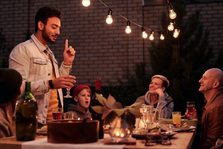 Man giving a toast at a backyard dinner party.