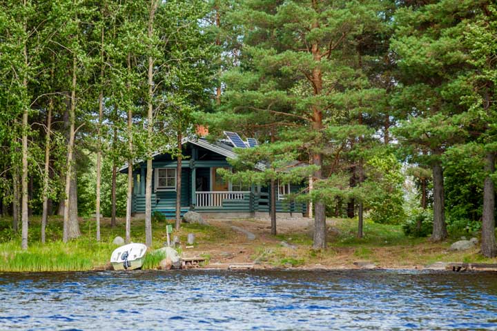 A small motorboat is shored near a lake home in the peak boating season.