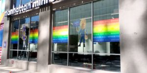 Windows of a Manhattan Mini Storage location with rainbow "space for all" and animated character window clings