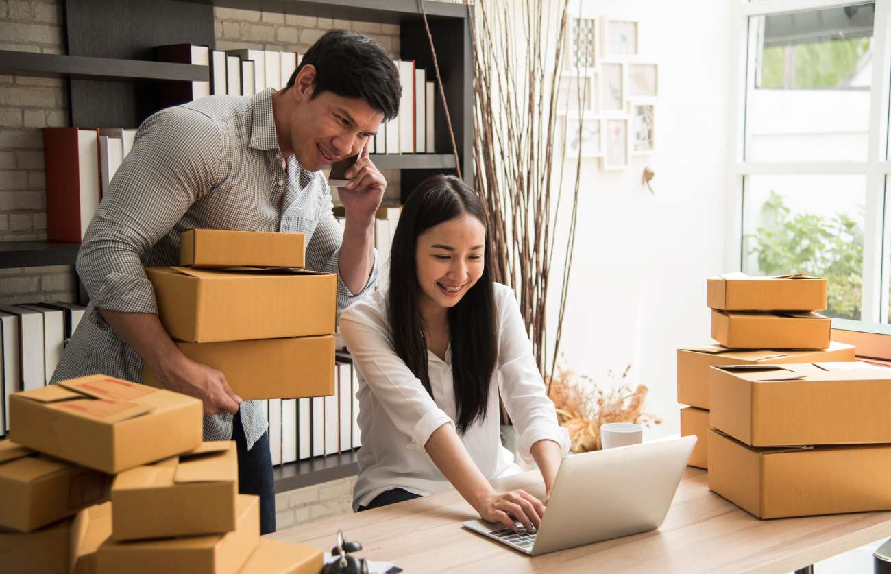 Two people working on online business surrounded by inventory