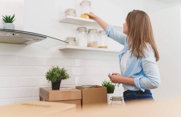 Lady stocking kitchen shelf